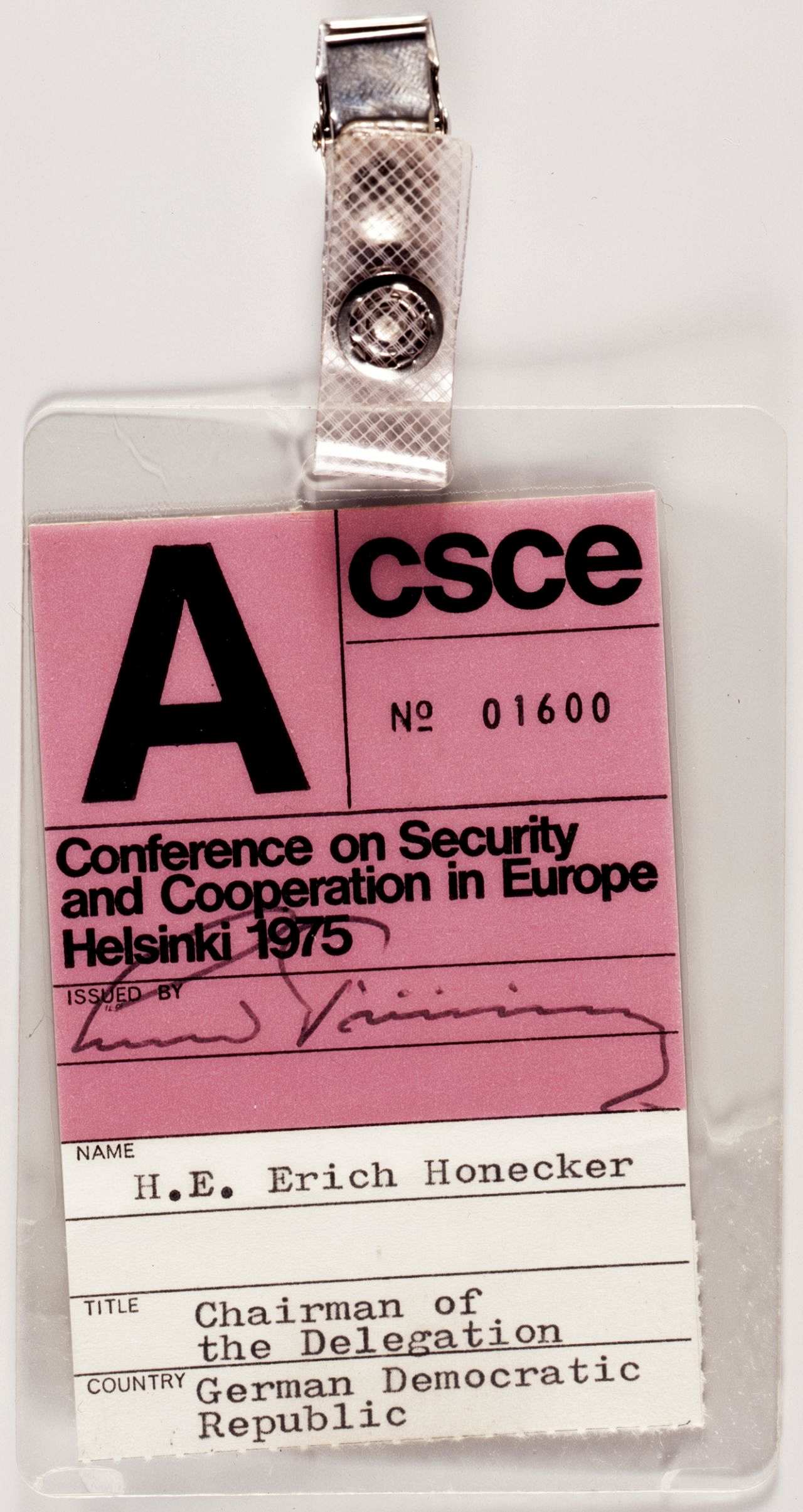 Eingeschweißter Ausweisvordruck, maschinenschriftlich ausgefüllt: No. 01600, Conference on Security and Cooperation in Europe Helsinki 1975, Name: H.E. Erich Honecker, Title: Chairman of the Delegation, Country Germany Democratic Republic, oben Metallclip.